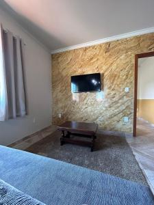 a bedroom with a tv on a stone wall at Apartamento Santa Cruz in Santa Cruz +17 photos