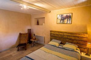 a bedroom with a bed and a picture of a horse at Appartement Le Licol in Petite Sainte-Anne