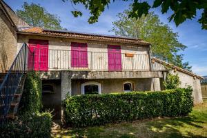 an old house with pink doors and a fence at Appartement Le Licol in Petite Sainte-Anne