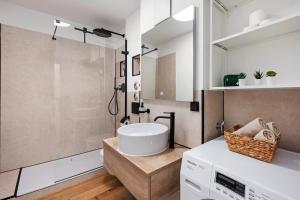 ein Badezimmer mit einem weißen Waschbecken und einer Dusche in der Unterkunft EDLER WOHNRAUM Luxuriöses Apartment mit Balkon, Boxspringbett, Kaffeevollautomat, Lift & Parkplatz in Chemnitz