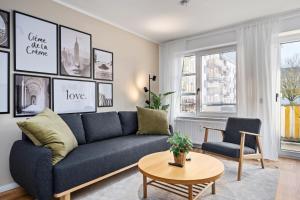 ein Wohnzimmer mit einer blauen Couch und einem Tisch in der Unterkunft EDLER WOHNRAUM Luxuriöses Apartment mit Balkon, Boxspringbett, Kaffeevollautomat, Lift & Parkplatz in Chemnitz