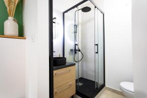 a bathroom with a glass shower with a sink at Nid Calme en Hypercentre - Proche Métro & Gare in Toulouse