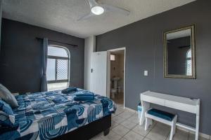 Un dormitorio con una cama, un escritorio y un espejo. en Seagull 514, en Margate 8 fotos más