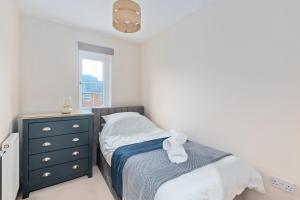 a bedroom with a bed and a dresser and a window at Redhill,Sleeps9,Parking,17minsLGW30 to London in Merstham