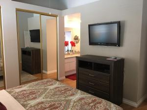a bedroom with a bed and a television on a wall at Tranquil 3BR Home w Private Pool Spa in La Quinta