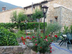 a garden with roses and a street light and a building at Casa Rural Cal Farragetes in Tuixen