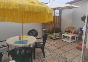 a patio with a table and chairs and an umbrella at Piscina club pasito blanco in Pasito Blanco