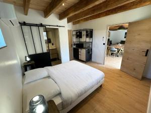 a bedroom with a bed and a kitchen with a table at Gîte de Condeiss in Condeissiat