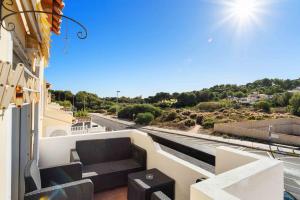 balcón con sofá y vistas a la calle en HE Panorama Villamartin, en Orihuela Costa