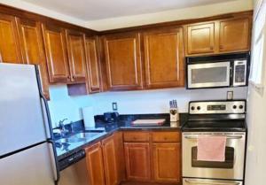 Una cocina con gabinetes de madera y un horno de estufa. en Top-floor view, Walk to Sanford Stadium, en Athens