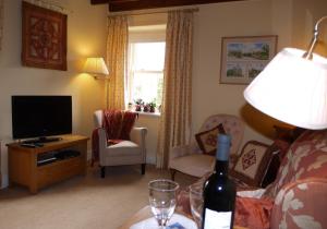 a living room with a bottle of wine on a table at Corner House in Grinton +16 photos