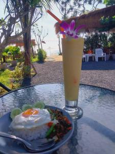 a plate of food and a drink on a table at Walden Koh Lanta - Tiny Homes by the Sea in Ko Lanta