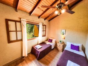 a bedroom with two beds and a ceiling fan at Complejo el Paine in Villa General Belgrano +15 photos