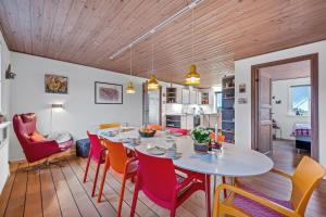 a dining room and living room with a table and chairs at Lovely Holiday House With 4 Rooms Close To The North Sea in Frøstrup