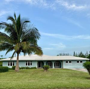 a palm tree in front of a white building at Balihamas Villa in Freeport