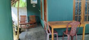 a dining room with a wooden table and chairs at Green House Yala in Kirinda