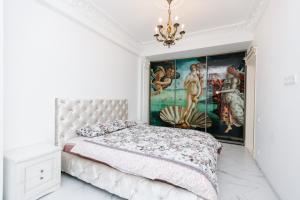 a bedroom with a bed with a painting on the wall at SkyHouse-High Comfort Gem in Central Downtown in Chişinău