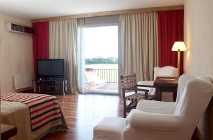a hotel room with a television and a living room at Pampas de Areco Resort de Campo & Spa in San Antonio de Areco