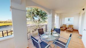 Un comedor con mesa y sillas en un balcón. en Charming 2 Bed Apartment with Golf Course Views, en Sucina