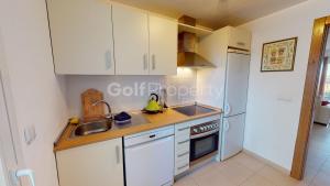cocina con armarios blancos, fregadero y nevera en Charming 2 Bed Apartment with Golf Course Views, en Sucina 7 fotos más