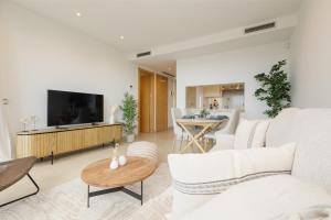 a living room with a white couch and a tv at Beautiful modern holiday apartment in Marbella