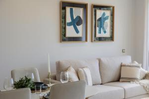 a living room with a couch and two pictures on the wall at Beautiful modern holiday apartment in Marbella