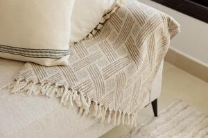 a pillow sitting on a chair with a blanket at Beautiful modern holiday apartment in Marbella