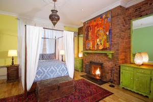 a bedroom with a canopy bed and a fireplace at Auberge Les Bons Matins in Montréal