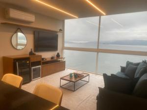 a living room with a couch and a tv and a table at Lar Doce Mar in Angra dos Reis