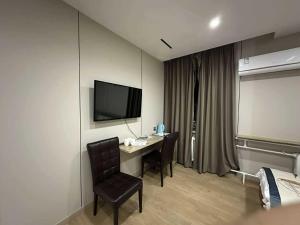 a room with a desk with a tv and a chair at Erkhes hotel in Dalandzadgad