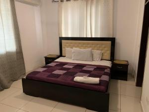 アクラにあるHuge 3 bed in heart of the city!の大きなベッドと2つのナイトスタンドを備えた寝室