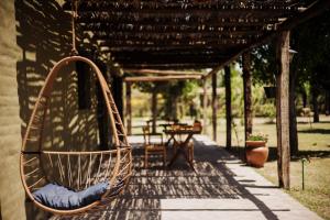 un columpio de mimbre colgando de una pérgola en El Pinar Caballeriza, en San Rafael