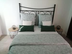 a bedroom with a large bed with green and white pillows at TROPIK, Chic 15 min de Paris Quais de Seine in Athis-Mons