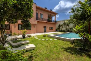 an exterior view of a house with a swimming pool at Amelia D Art Deco Suites in Seminyak