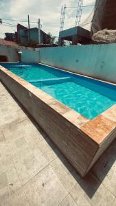 a large swimming pool with blue water in at Casa em Porto de Galinhas in Porto De Galinhas