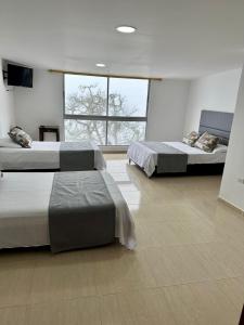 una camera da letto con due letti e una grande finestra di Hotel Campestre, El Balcón a Santa Bárbara