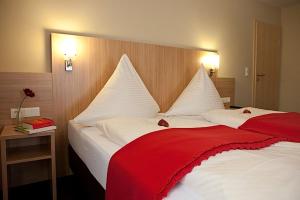 En eller flere senge i et værelse på Hotel Rosenhof Garni