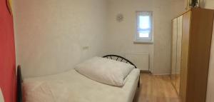 Una pequeña habitación con una cama y una ventana. en Apartment Gosberg - 90qm, en Pinzberg
