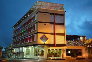 um edifício alto com uma placa na lateral em Hotel San Carlos em Barrancabermeja