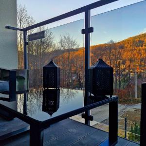 a balcony with a view of a reflection in a window at Apartamenty Spokoloko Ostoja Beskidy ARKTYKAloft i Rapa Nui in Szczyrk
