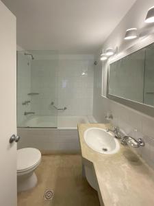a bathroom with a sink and a toilet and a tub at La Posta Beach Hotel in Punta del Este