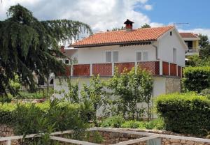 ein weißes Haus mit einem roten Dach in der Unterkunft Apartment Ljerka in Malinska