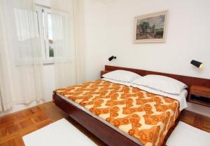 ein Schlafzimmer mit einem Bett in einem Zimmer in der Unterkunft Apartment Ljerka in Malinska