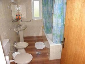 a bathroom with a toilet and a sink and a tub at Apartments Pondeljak in Malinska