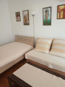 a room with two beds and a table at Apartments Pondeljak in Malinska