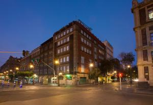 a large brick building on a city street at night at Zocalo Central & Rooftop Mexico City in Mexico City