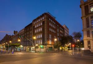 a large brick building on a city street at night at Zócalo Central in Mexico City