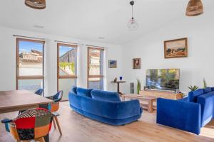 ein Wohnzimmer mit blauen Sofas und einem Tisch in der Unterkunft Grande Villa de 400m2 21 Personnes en centre ville de Toulouse in Toulouse