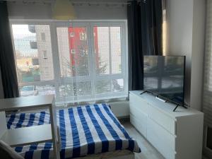 a bedroom with a tv and a dresser and a window at One Rent in Braşov