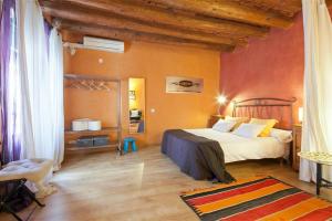 - une chambre avec un grand lit et des murs orange dans l'établissement Friendly Rentals Manuela, à Barcelone